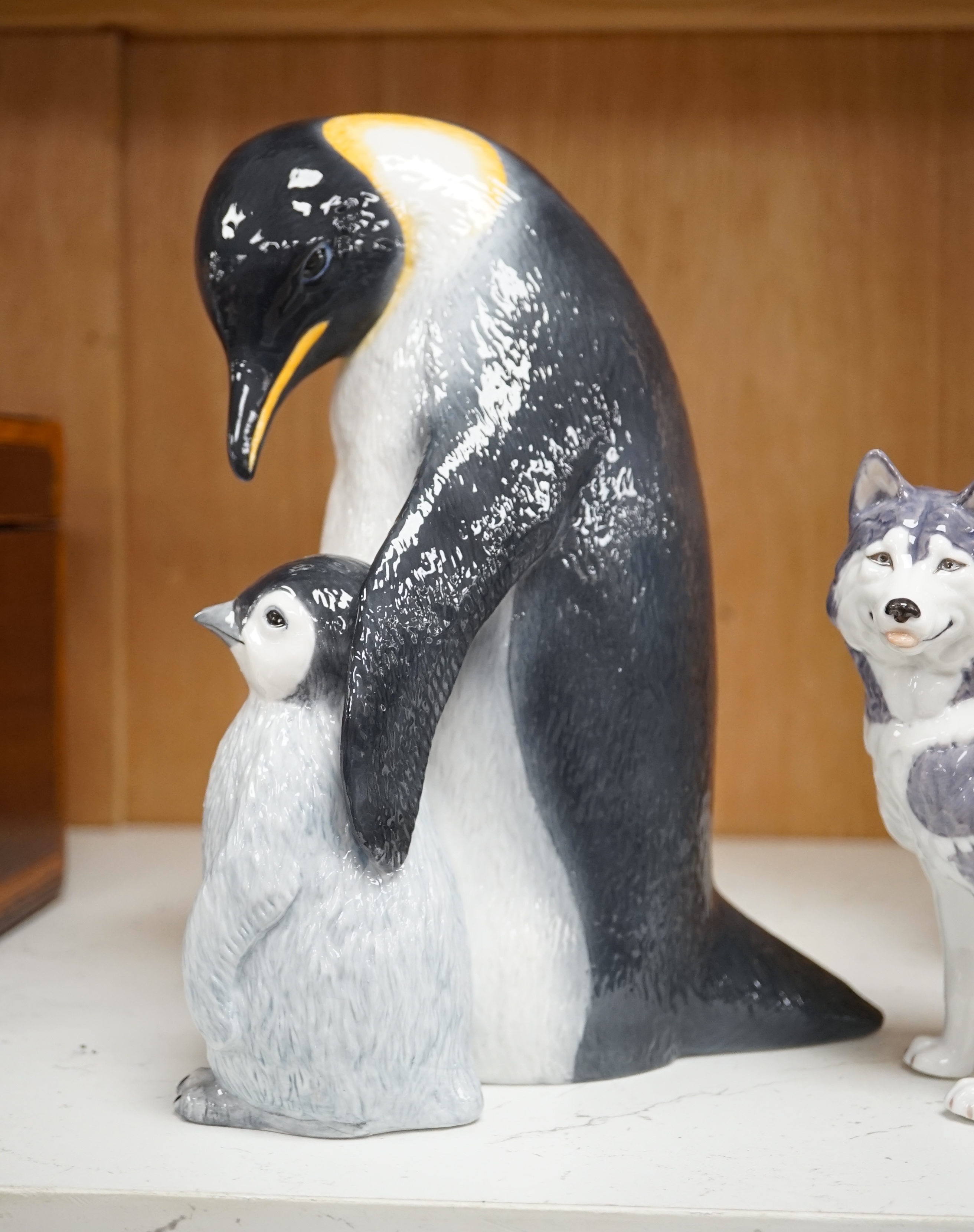 A Royal Copenhagen penguin group and a similar husky figure, 088 and 038, tallest 22cm. Condition - good